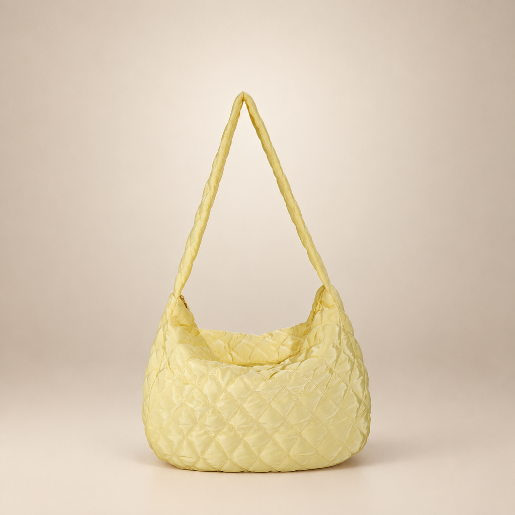 Quilted crossbody bag on a warm ivory studio background