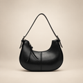 Black crescent shoulder bag on a warm ivory studio background