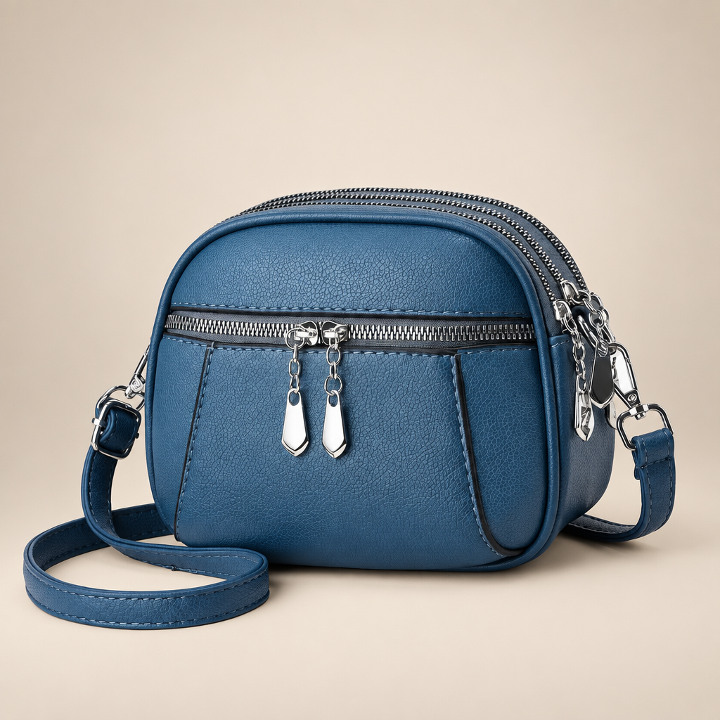 Small round crossbody bag on a warm ivory studio background