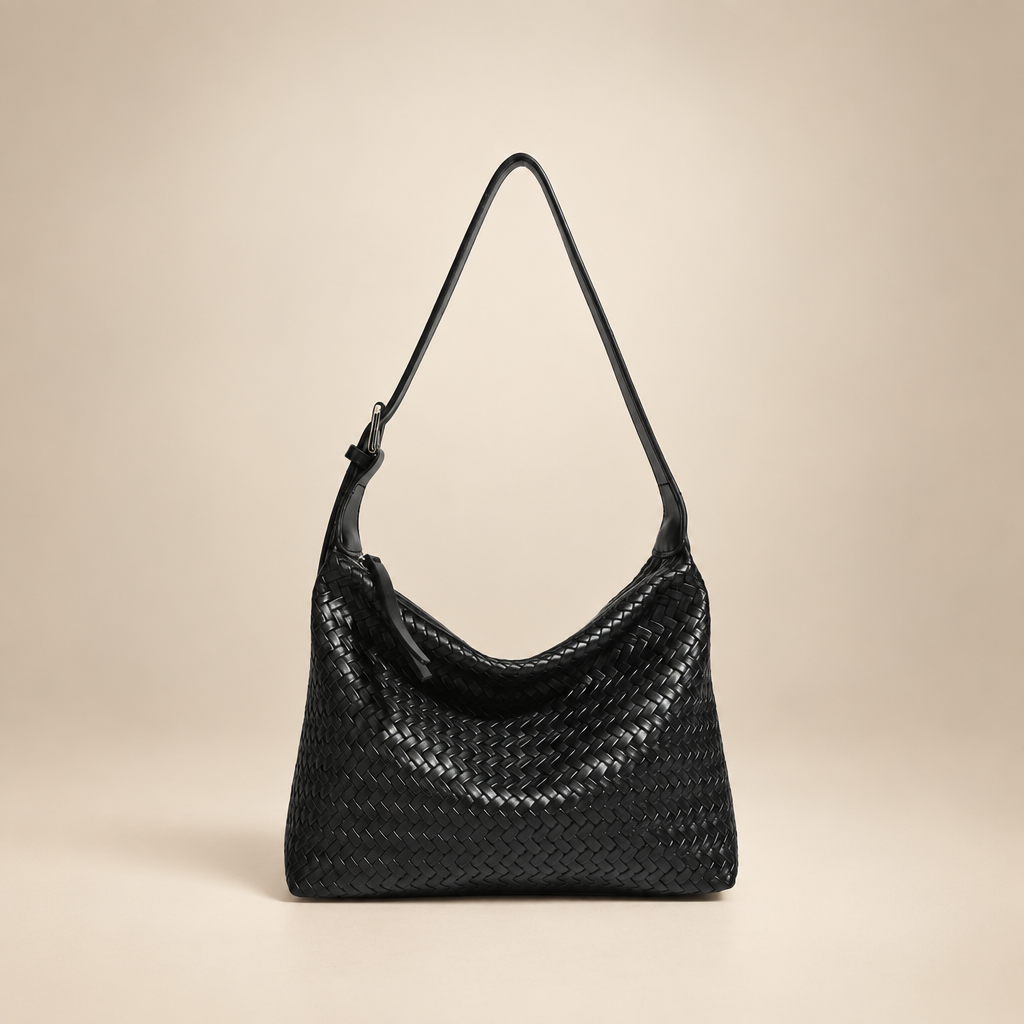 Black woven shoulder bag on a warm ivory studio background