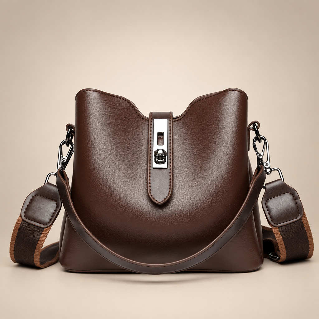 Brown bucket bag with silver hardware on a warm ivory studio background