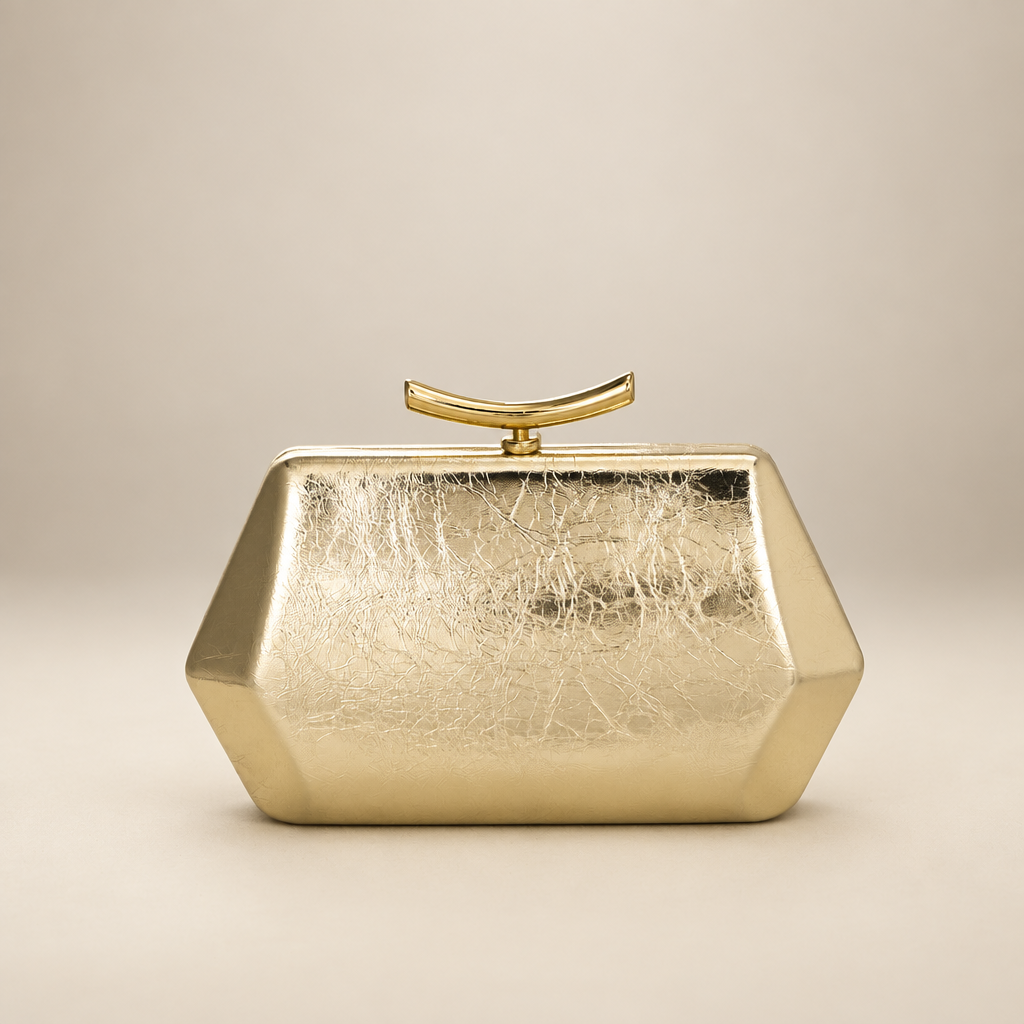 Gold faceted clutch, front view on warm ivory studio background