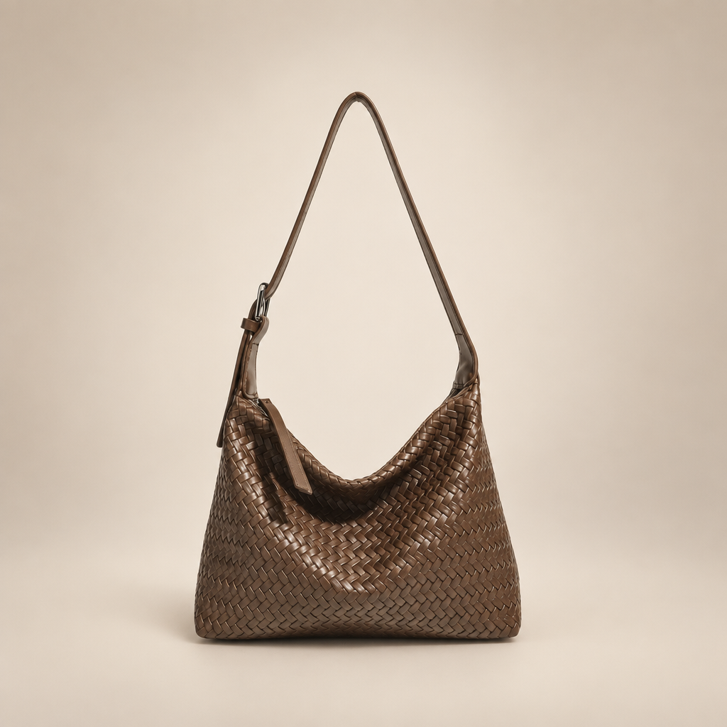 Brown woven shoulder bag on a warm ivory studio background