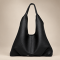 Women's slouchy shoulder tote in black on a warm ivory/taupe studio background