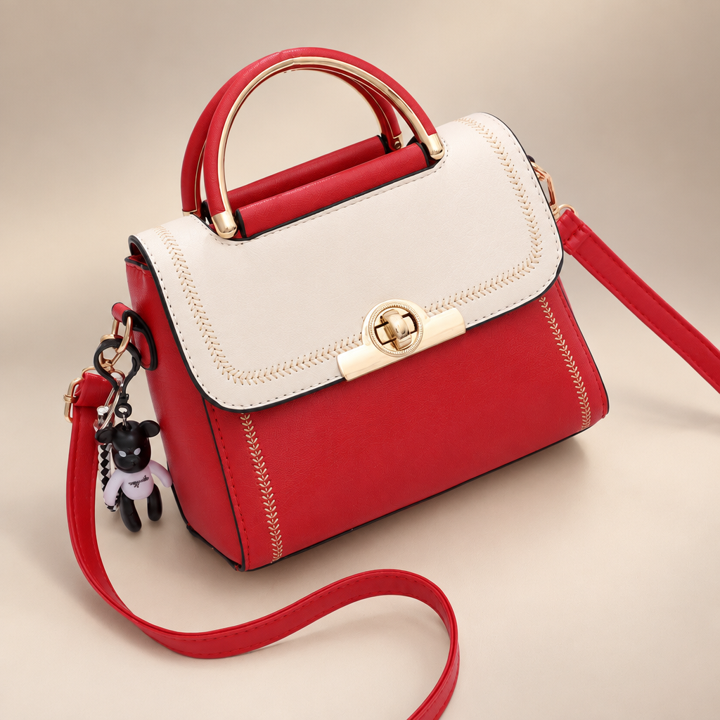 White And Red colour-block embroidered crossbody bag with red body, white flap, top handle and key charm on a warm ivory and taupe studio background