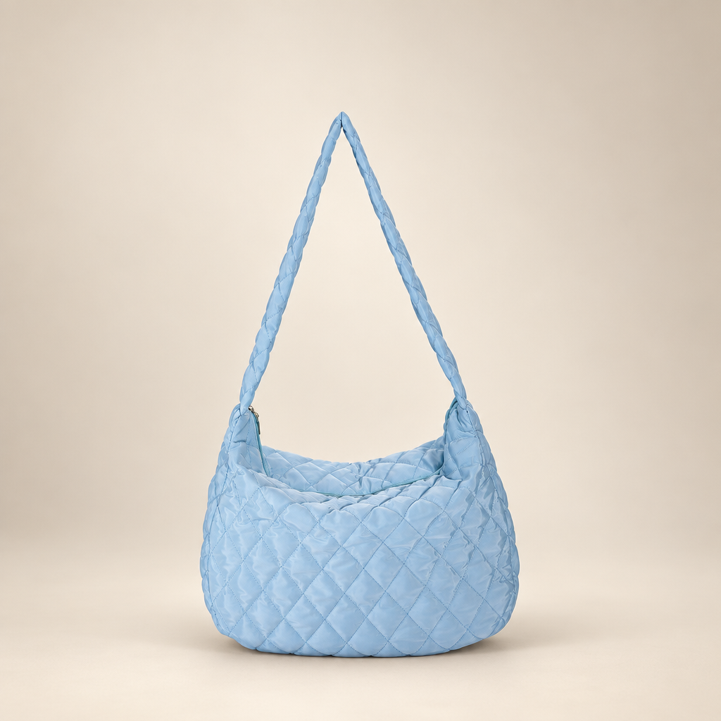 Quilted crossbody bag on a warm ivory studio background