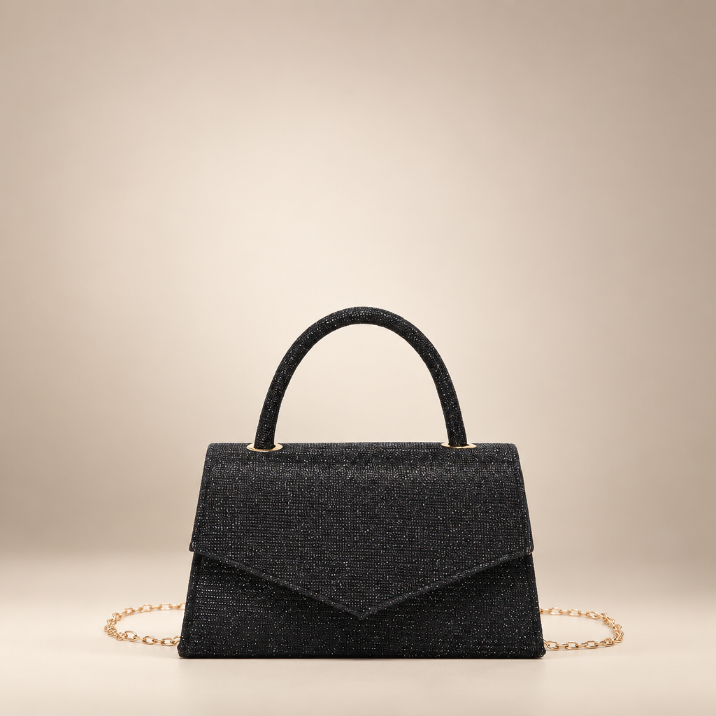 Black small square PU handbag with a top handle and chain strap on a warm ivory studio background