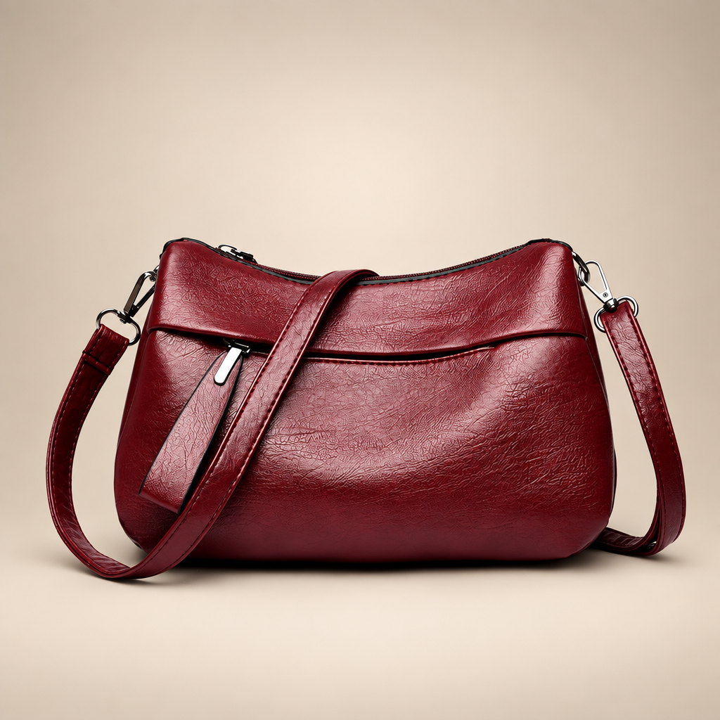 Wine red textured shoulder bag on a warm ivory studio background