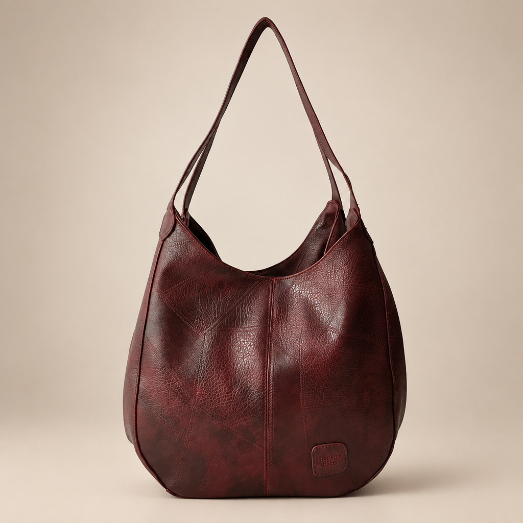Vintage women's shoulder bag in red on a warm ivory/taupe studio background