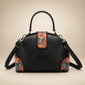 Black dome handbag with colourful floral panels on an ivory studio background