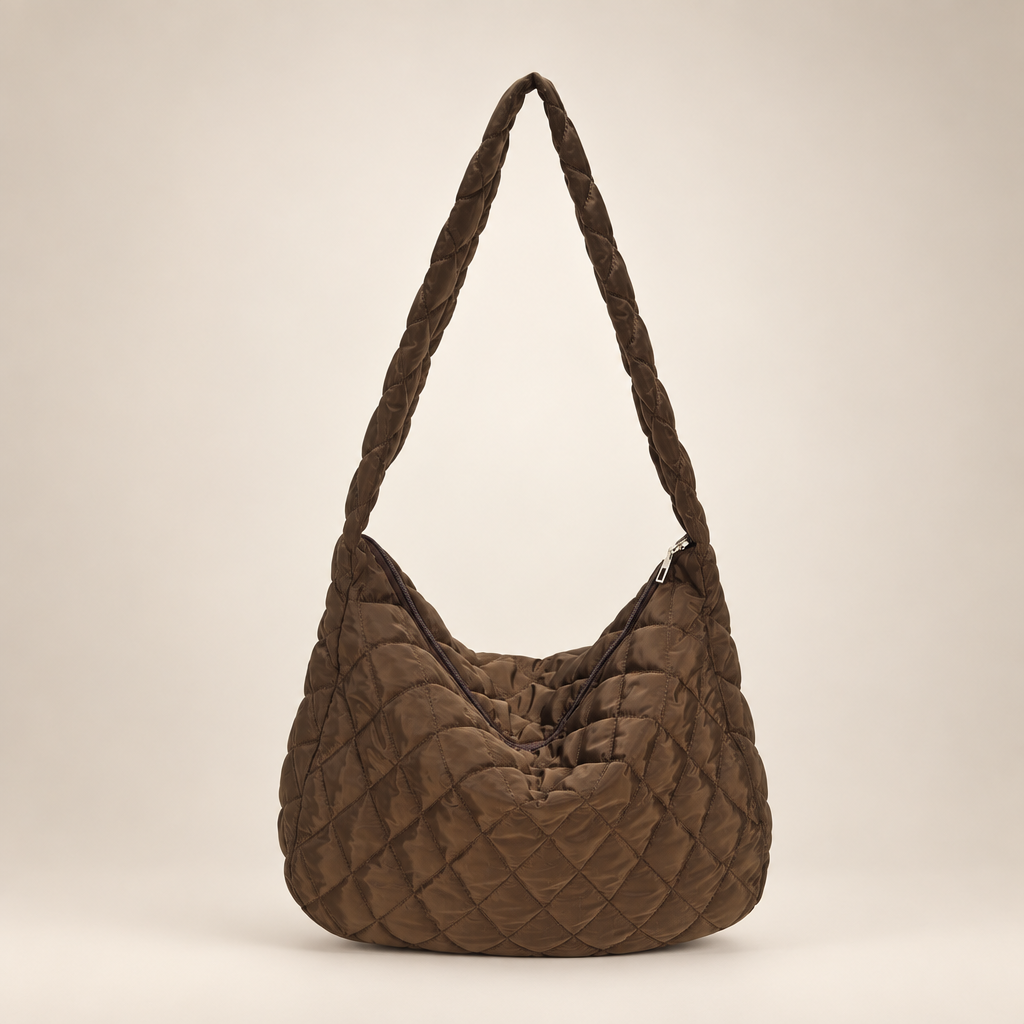 Quilted crossbody bag on a warm ivory studio background