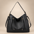 Women's slouchy hobo shoulder bag in black on a warm ivory/taupe studio background