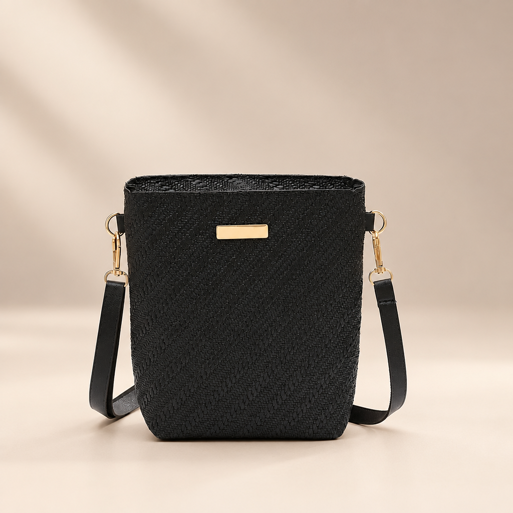 Black PU shoulder bag with embossed texture against a warm ivory and taupe studio background