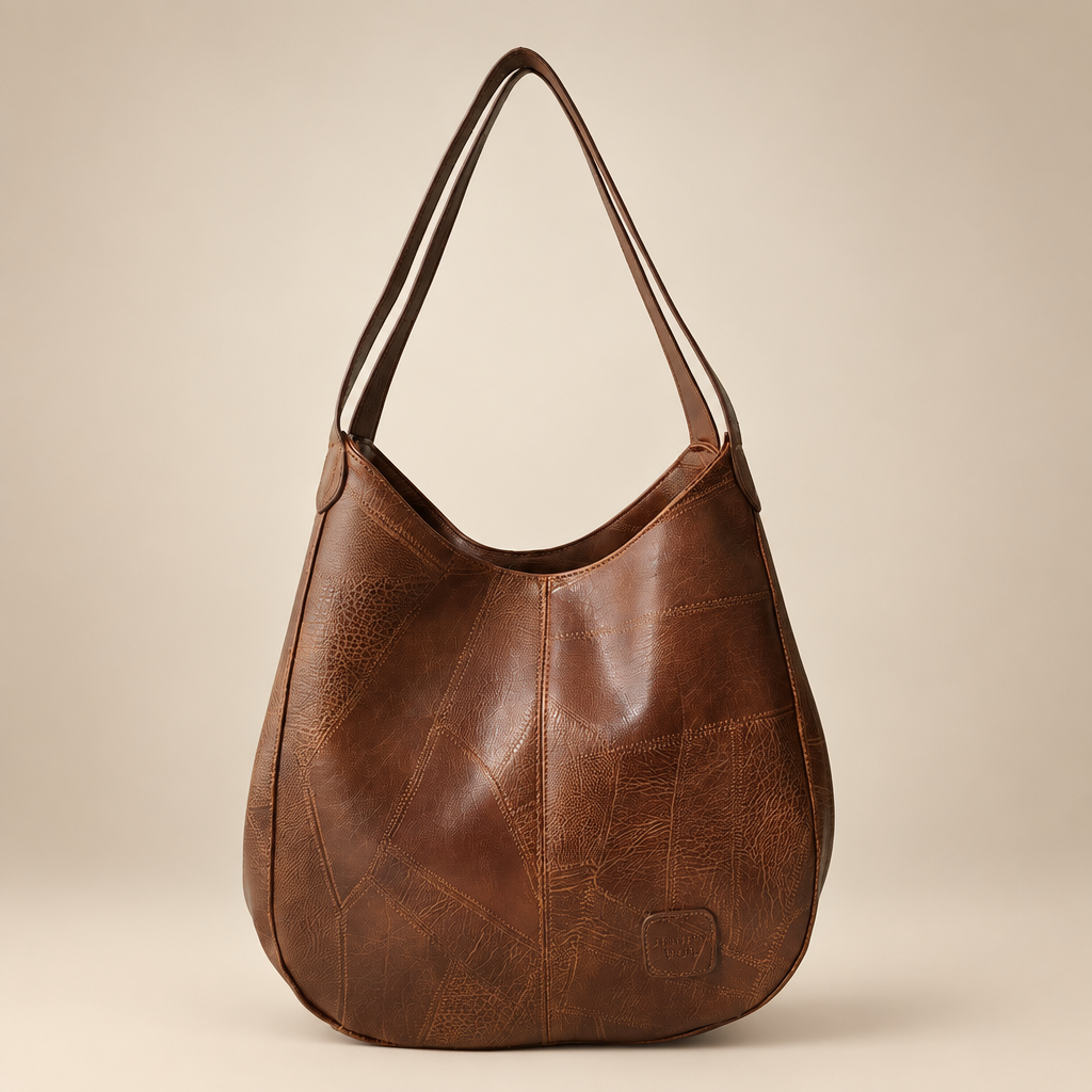 Vintage women's shoulder bag in brown on a warm ivory/taupe studio background