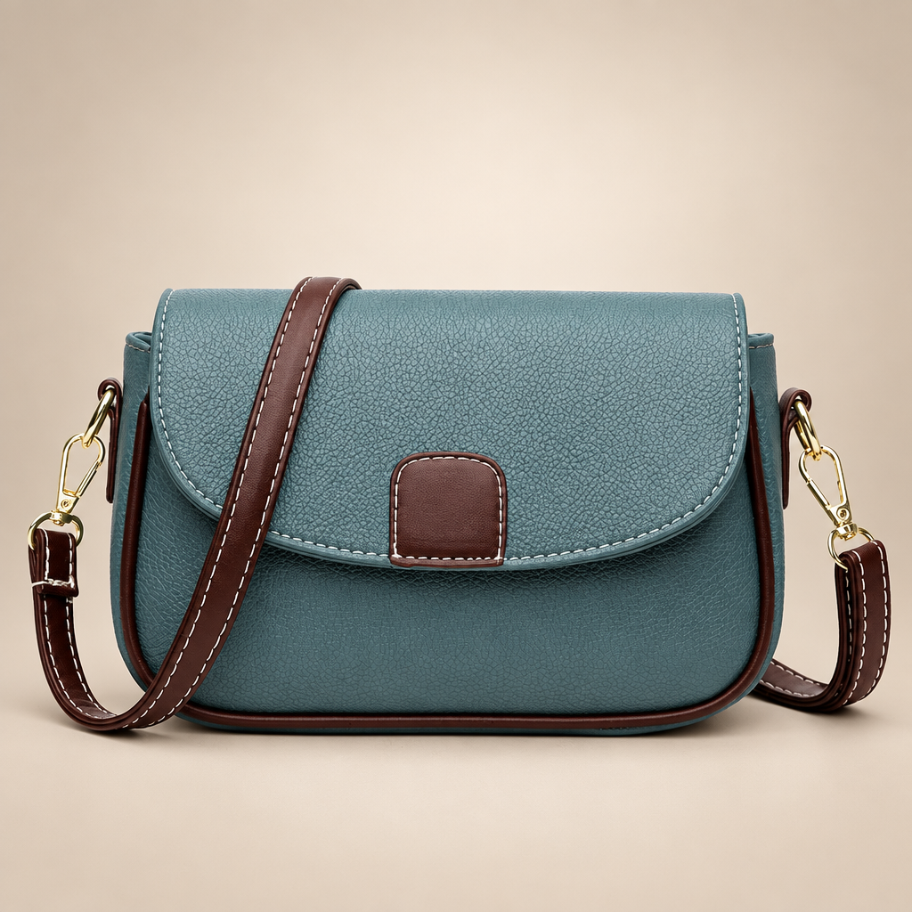 Women's small flap crossbody bag in blue on a warm ivory/taupe studio background
