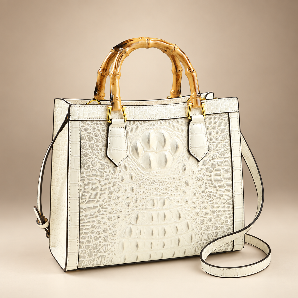 Ivory croc-embossed handbag with bamboo-style handles on an ivory studio background