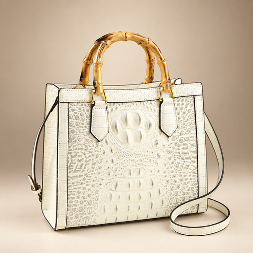 Ivory croc-embossed handbag with bamboo-style handles on an ivory studio background