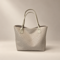 Beige woven PU shoulder bag with double straps on a warm ivory and taupe studio background