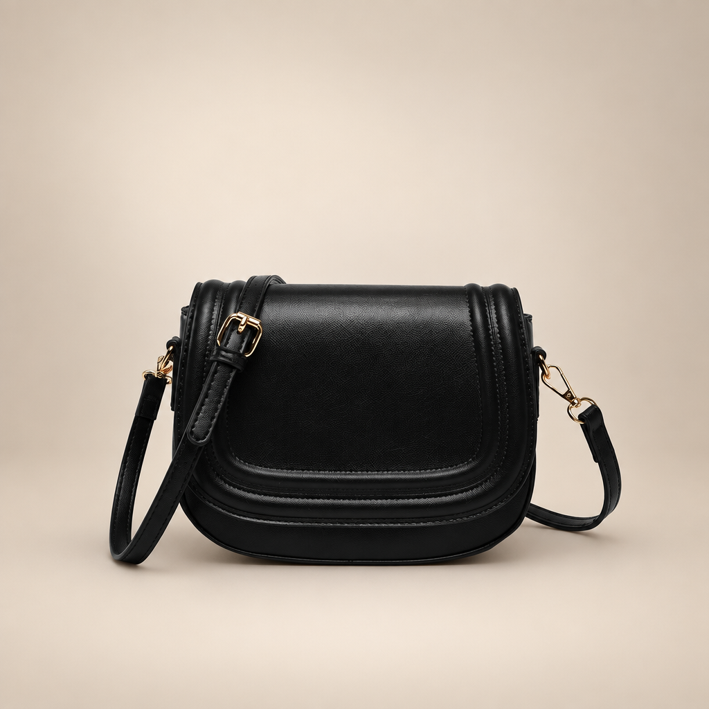 Black curved-flap crossbody bag on a warm ivory studio background