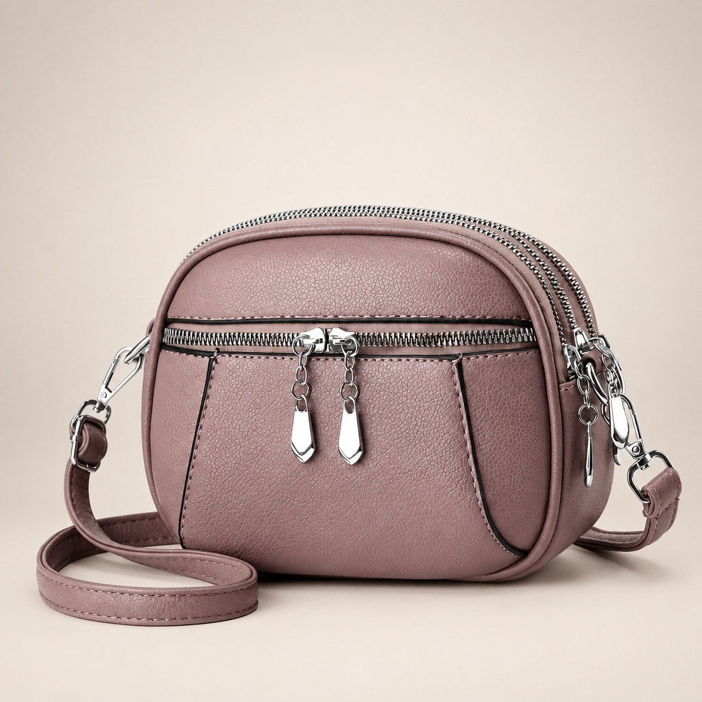 Small round crossbody bag on a warm ivory studio background