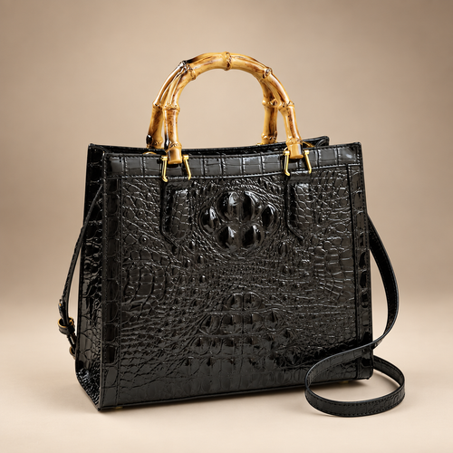 Black croc-embossed handbag with bamboo-style handles on an ivory studio background