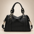 Black handbag on a warm ivory studio background