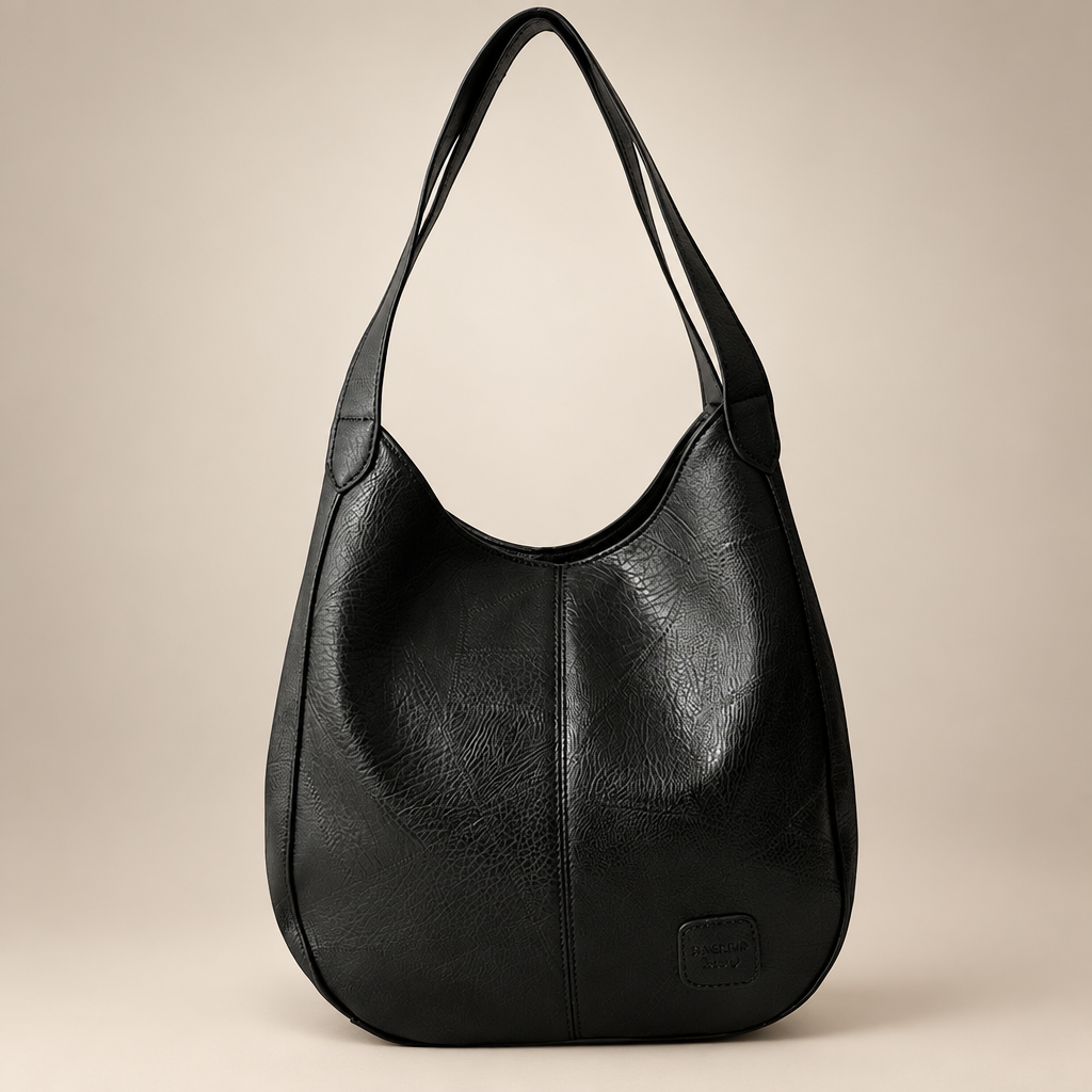 Vintage women's shoulder bag in black on a warm ivory/taupe studio background