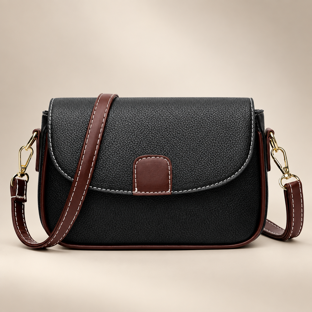 Women's small flap crossbody bag in black on a warm ivory/taupe studio background