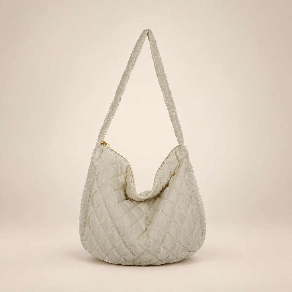 Quilted crossbody bag on a warm ivory studio background