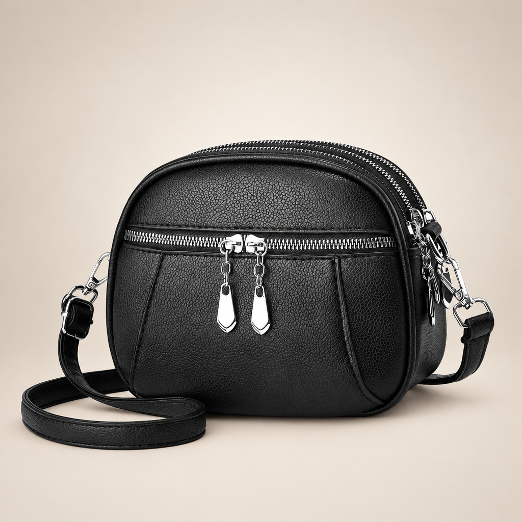 Small round crossbody bag on a warm ivory studio background