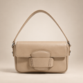 Beige flap shoulder bag on a warm ivory studio background