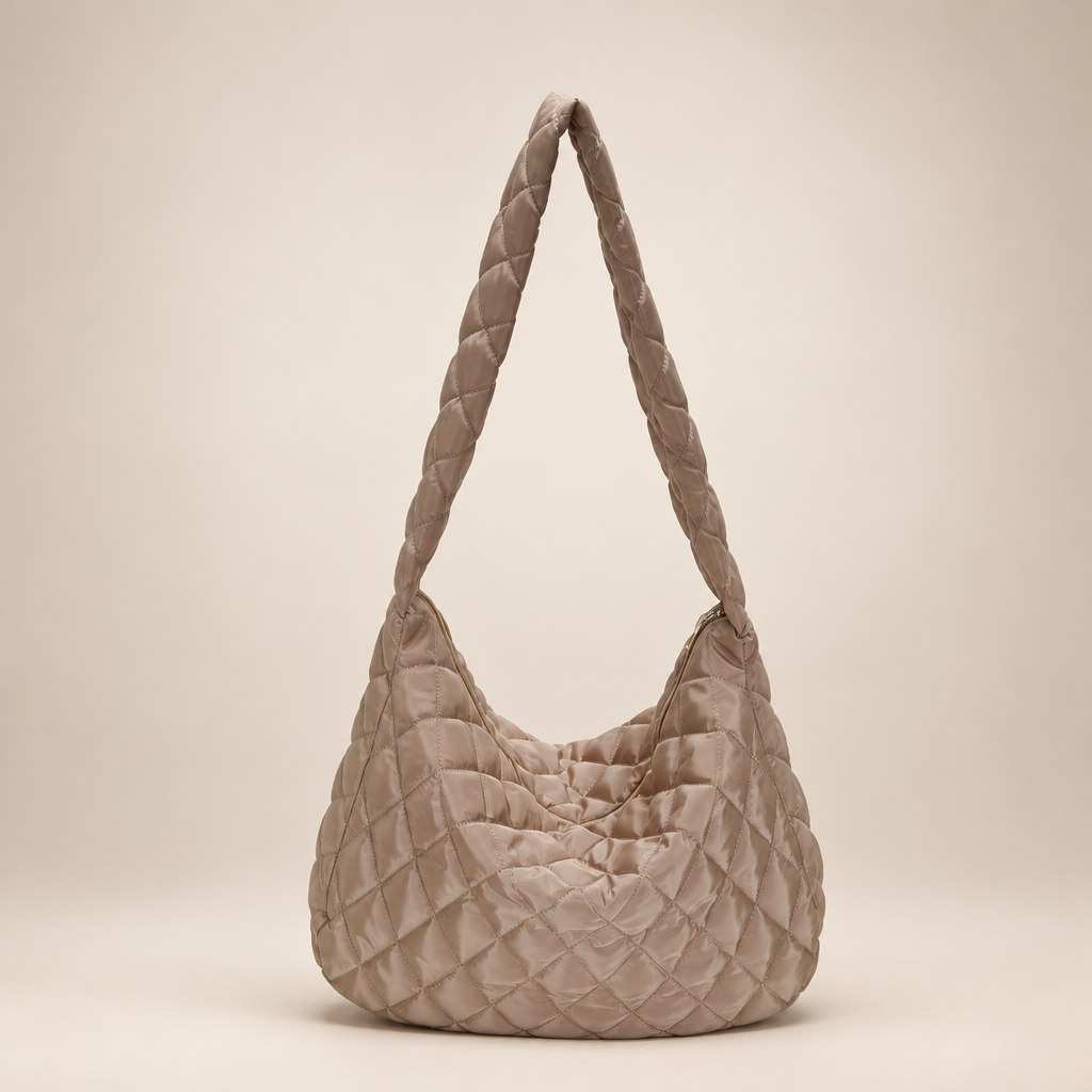 Quilted crossbody bag on a warm ivory studio background